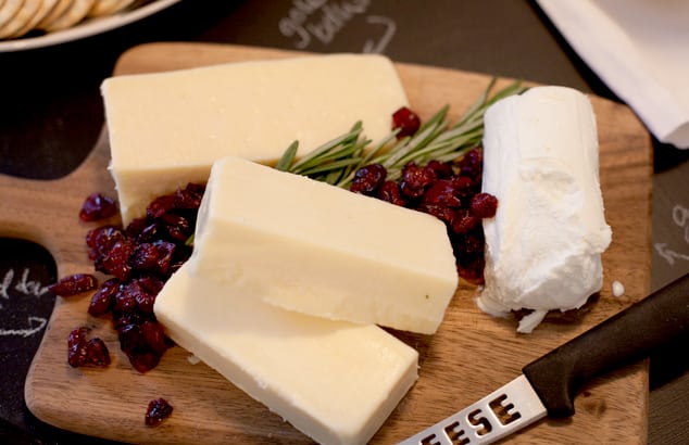 instant appetizer holiday hack. Image of cheese and cranberries on wood cutting board.