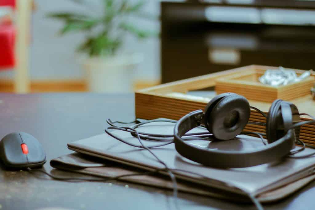 headphones and mouse for computer on top of a folder on a table