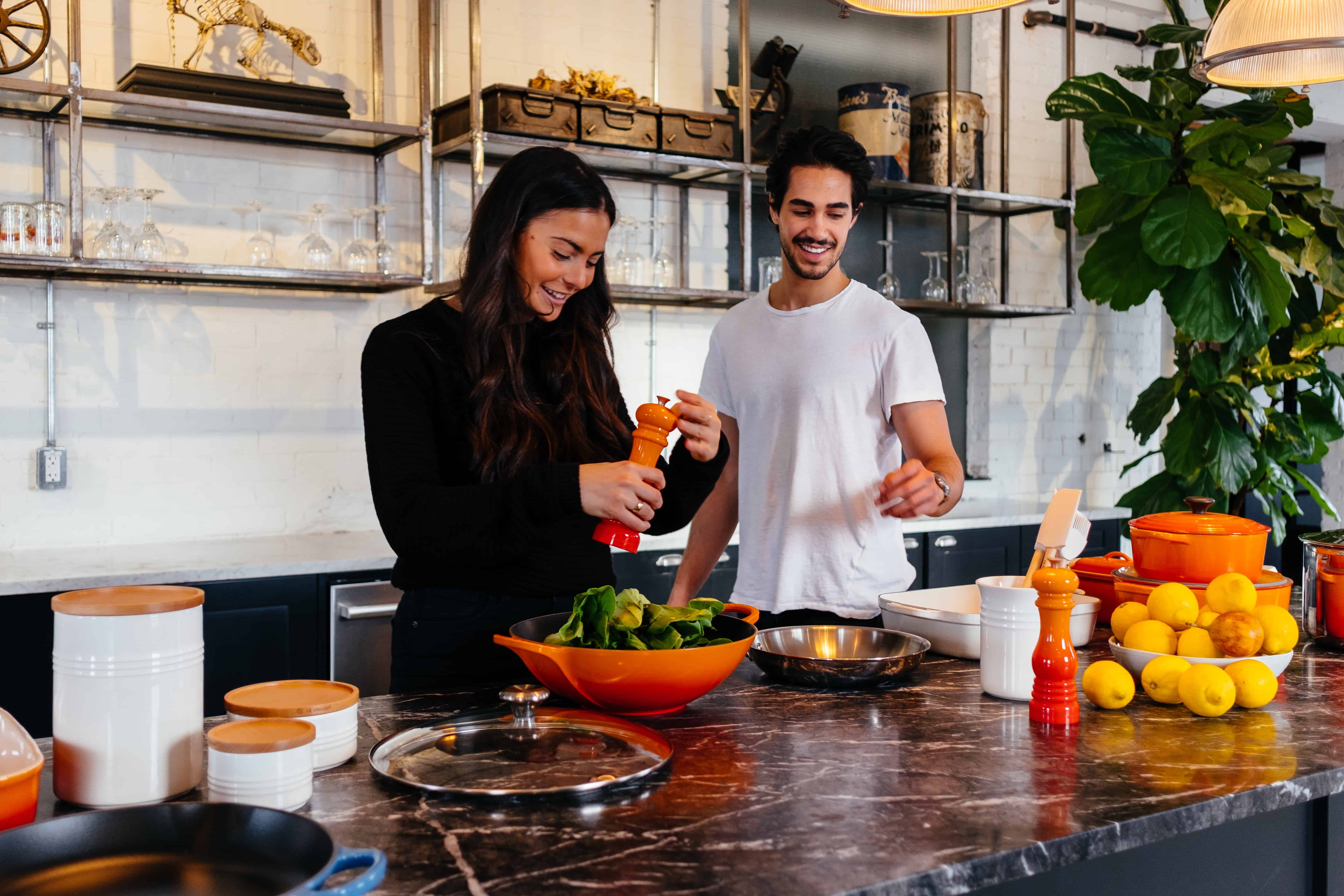 2 people making a salad in a kitchen