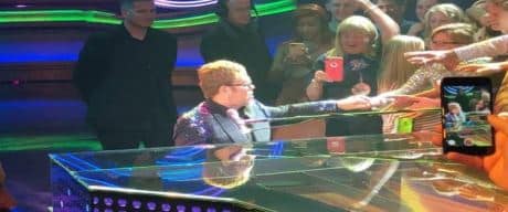 Elton John in concert on piano.