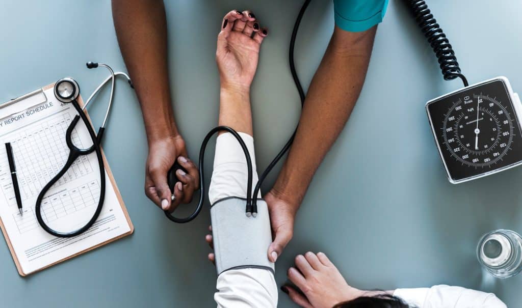 Image of Doctor or nurse performing a blood pressure check on a patient. 