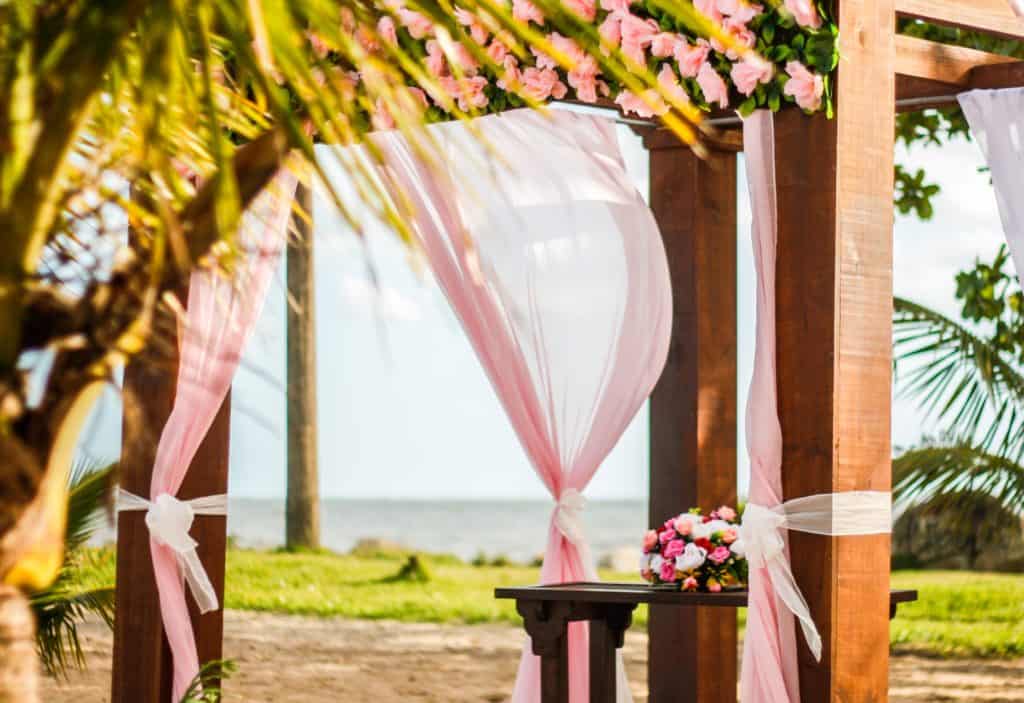 Wedding venue gazebo decorated with pink ribbons.