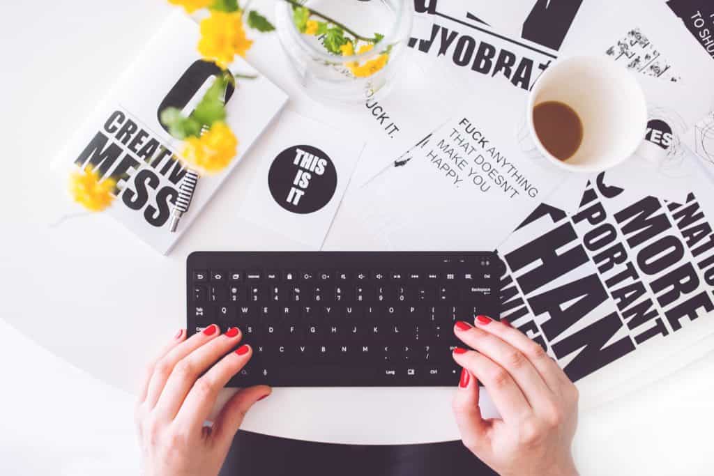 Pay off debt ideas freelance. image if woman on keyboard with coffee cup.