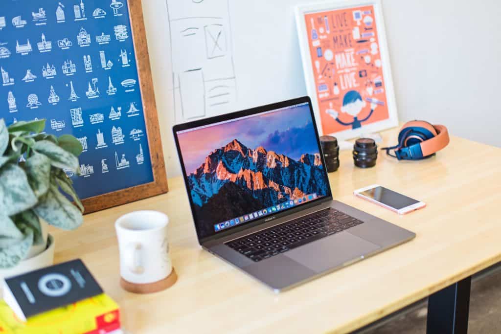 online jobs for college students in post image 4. Image of laptop, coffee mug, pant, and headphones on desk.