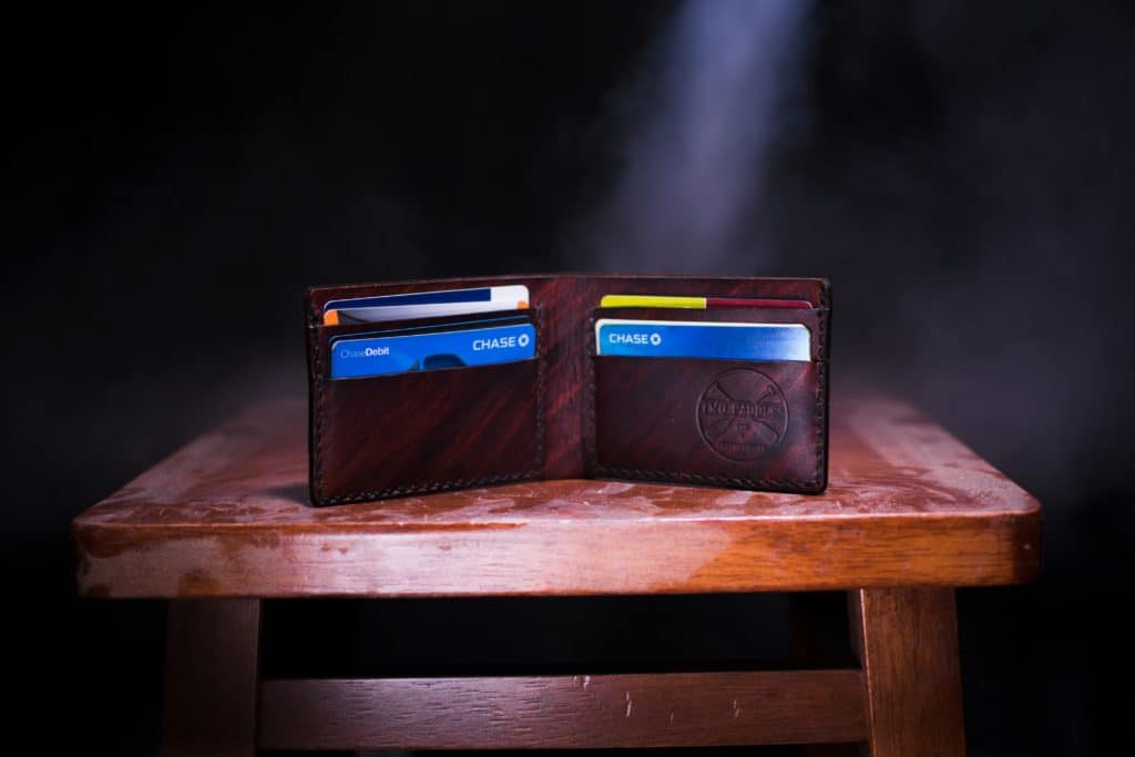 Ways to make your credit card work for you in post. image of opened wallet with credit cards on table. 