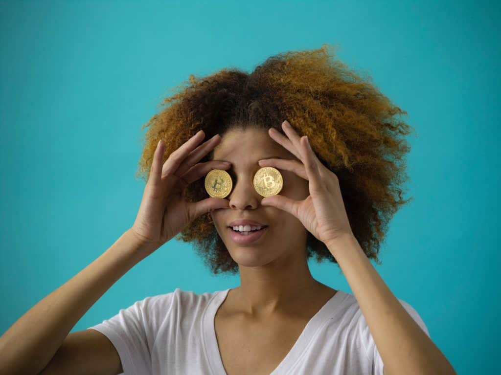 passive income ideas 2019 investing. Image of woman holding gold coins to her eyes.