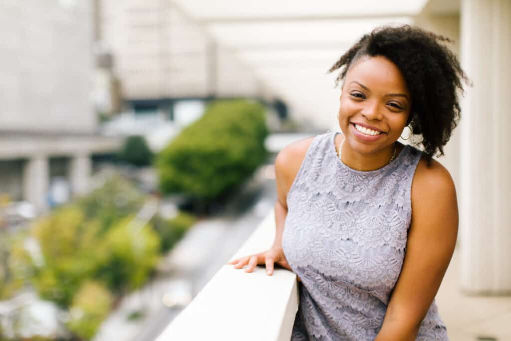 Danielle Desir standing on a balcony smiling at the camera