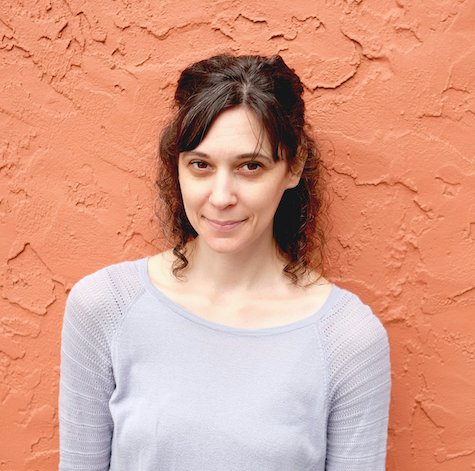 Dana author headshot against an orange wall